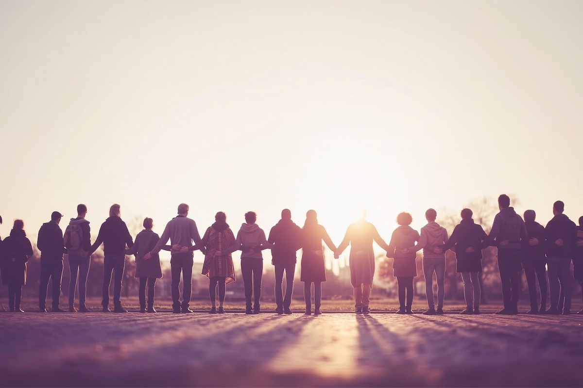 Viele Menschen stehen in einer Reihe als Menschenkette, sie sind von hinten zu sehen